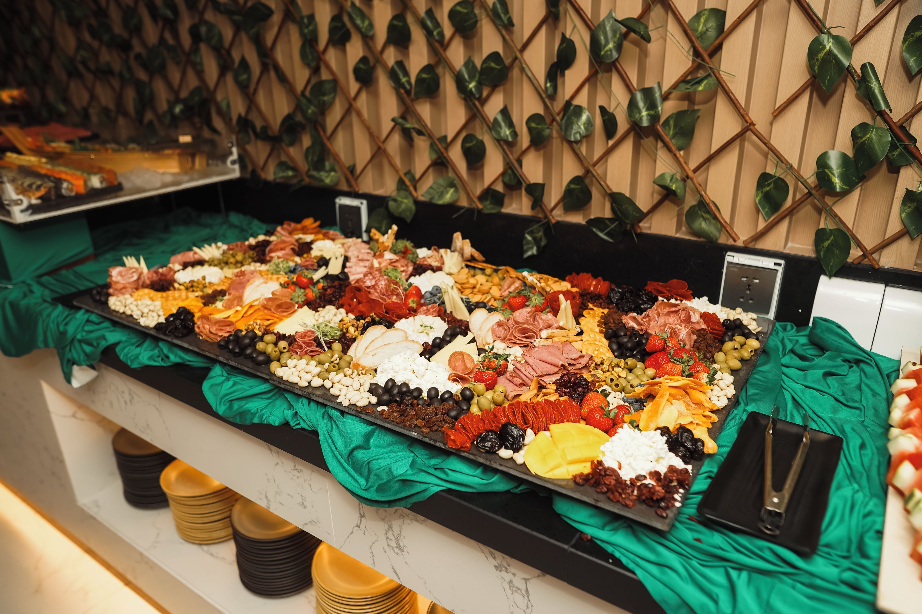A buffet spread with various food items and a green cloth covering.