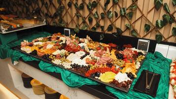 A buffet spread with various food items and a green cloth covering.