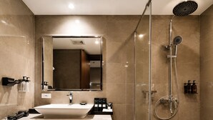 A modern bathroom with a large mirror, a sink, and a shower with a handheld showerhead. - Wyndham Garden Manila Bay (Parañaque)