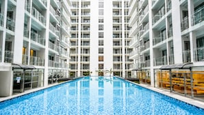 A modern hotel interior with a central swimming pool, multiple balconies, and a clean, contemporary design. - Wyndham Garden Manila Bay (Parañaque)