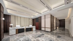 A modern hotel lobby with a marble reception desk, dark wood paneling, and a polished floor. - Days Hotel By Wyndham Changsha Xingsha (Changsha)