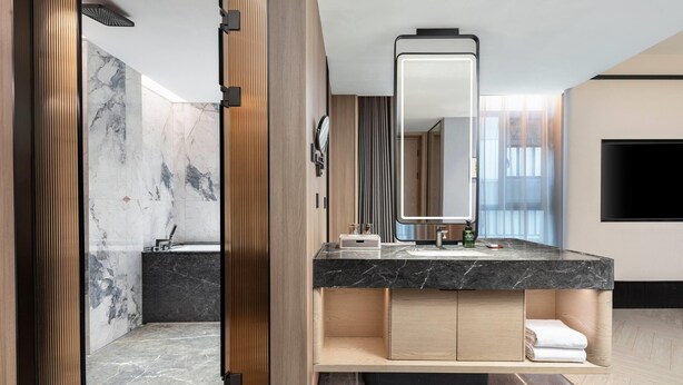 A modern bathroom with a marble vanity, a large mirror, and a built-in sink. - Days Hotel By Wyndham Changsha Xingsha (Changsha)