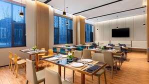 A modern dining area with tables, chairs, and a large window providing a view of the city. - Days Hotel By Wyndham Changzhi Luzhou (Changzhi)