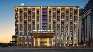 A multi-story hotel with a modern design, featuring a prominent entrance and illuminated signage. - Days Hotel By Wyndham Changzhi Luzhou (Changzhi)