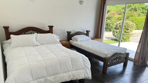 A bedroom with two beds, a large window, and a view of greenery outside. - Villa near Cartagena and its beaches, perfect to relax with privacy. (Cartagena)