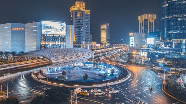 A roundabout with multiple lanes and traffic lights, surrounded by modern buildings with illuminated signage. - Jinglai Hotel ShanghaiWujiaochang Branch (Shanghai)