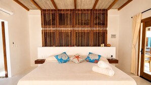 A hotel room with a bed, a wooden headboard, a nightstand, and a window with curtains. - Top Floor Suite +Pool +Private Path to Shore, A/C. Accessible step-less layout (San Pedro Pochutla)