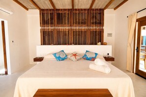 A hotel room with a bed, a wooden headboard, a nightstand, and a window with curtains. - Top Floor Suite +Pool +Private Path to Shore, A/C. Accessible step-less layout (San Pedro Pochutla)