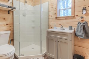 Een douche, handdoeken, zeep, toiletpapier