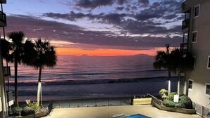 Ein Pool mit Blick auf den Ozean und den Sonnenuntergang.
