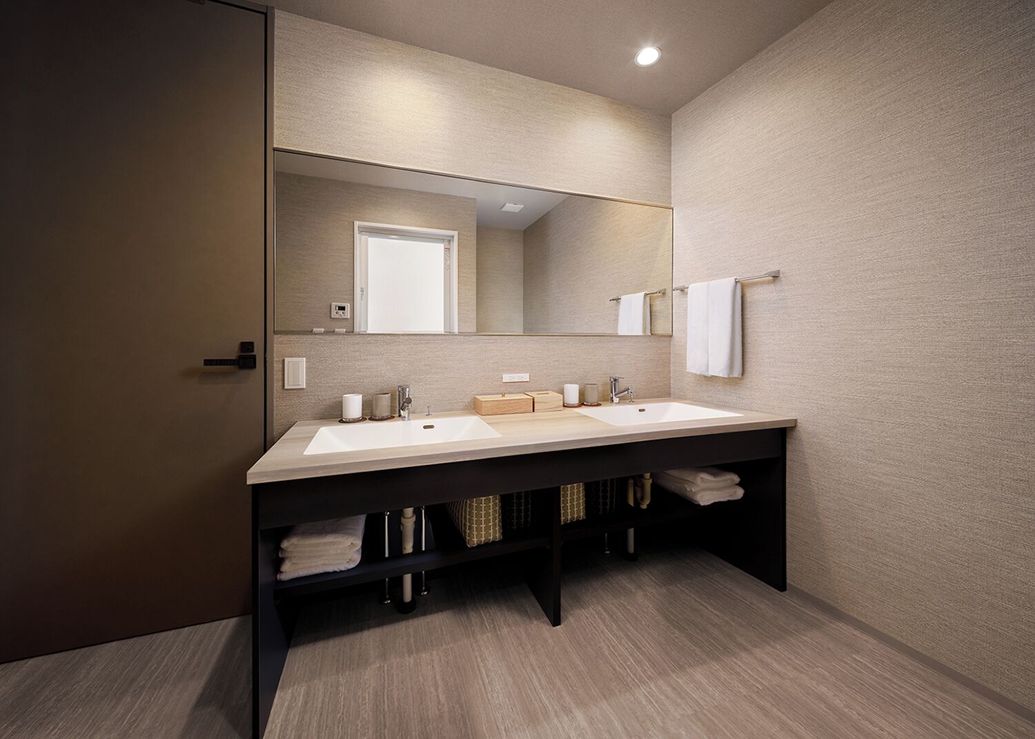 A modern bathroom with a double sink, a large mirror, and a towel rack.