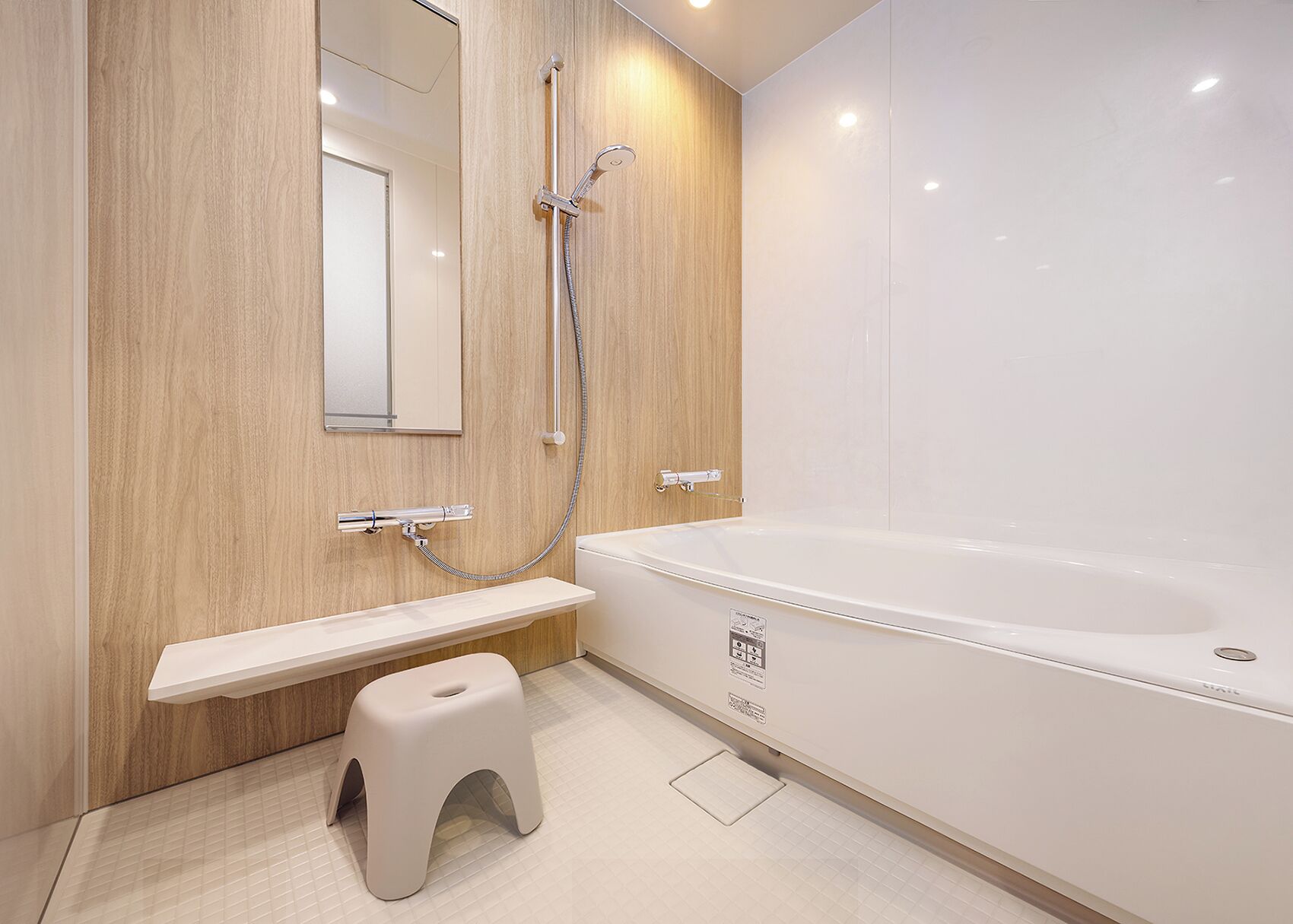 Un baño moderno con tocador de madera, una bañera blanca y un taburete pequeño.