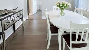 A dining area with a round white table, white chairs, and a ceiling fan. - 2BR Steps to Boardwalk & Beach, Walk to Casinos (Atlantic City)