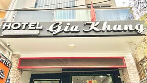 L’extérieur de l’hôtel Gia Khang se distingue par sa façade moderne, un panneau indicateur bien visible, de grandes fenêtres et une abondance de verdure.