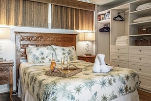 A bedroom with a bed, bedside tables, a wardrobe, and a hanging rack.