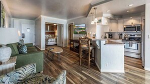 A modern kitchen with a central island, built-in appliances, and a dining area with a round table and chairs.