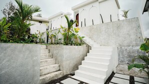 A concrete staircase leading to a white building with arched windows and a door. - Glamor Kintamani (Kintamani)
