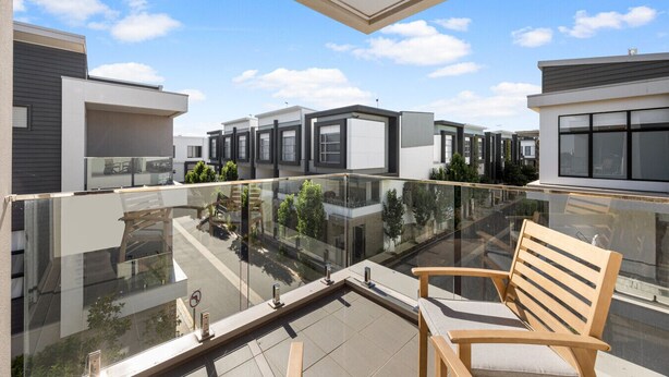 A modern apartment with a glass balcony, a wooden bench, and a view of neighboring buildings. - Loft & Levels @ Prospect - Contemporary Urban Living (Prospect)
