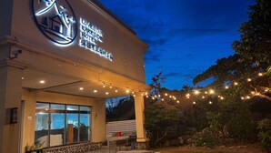 A hotel with a large illuminated sign, outdoor seating, and string lights. - STAR OF LOVE (Hengchun)