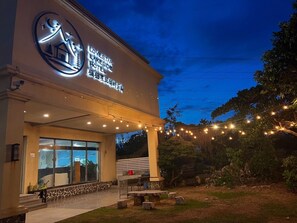A hotel with a large illuminated sign, outdoor seating, and string lights. - STAR OF LOVE (Hengchun)