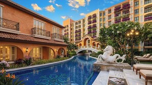 Un hôtel doté d’une piscine, d’un pont et d’une statue de cheval.