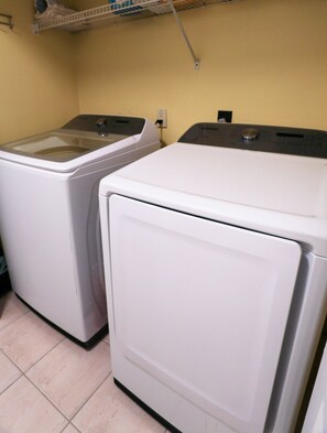 A laundry room with two front-loading washing machines and a shelf above them. - New Listing! Private Pool & Hot Tub! Near the Beach! (Panama City Beach)