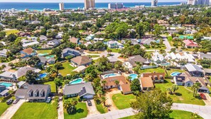 A residential area with houses, lawns, and a large body of water in the background. - New Listing! Private Pool & Hot Tub! Near the Beach! (Panama City Beach)