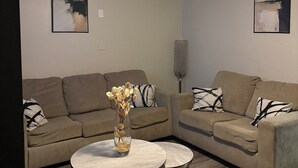 Un salon avec deux canapés, une table basse et un ventilateur de plafond.