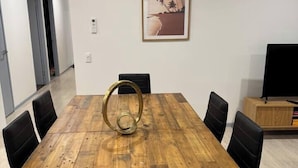 Ein Konferenzraum mit einem Holztisch, schwarzen Stühlen und einem gerahmten Bild an der Wand.