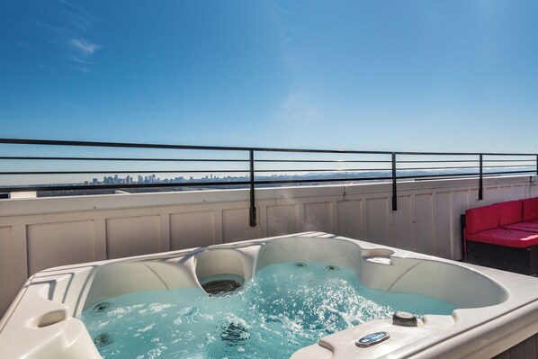 A hot tub with a city skyline in the background. - 27 Beds / Rooftop Hot Tubs + CityViews + Game Room (Nashville)