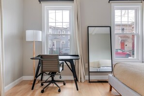 A room with a desk, chair, lamp, and a bed. - Blueground | Riverside, washer, nr Charles River (Cambridge)