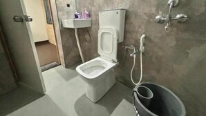 Een badkamer met toilet, wastafel en douche.