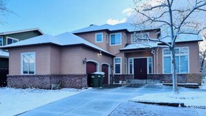 A two-story house with a brick foundation and a brown exterior. - Perfect 6-bedroom house with AC in welcoming Reno neighborhood (Reno)