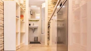 A modern kitchen with a built-in refrigerator, wooden flooring, and a visible sink area. - Holiday flat with terrace (Malinska)