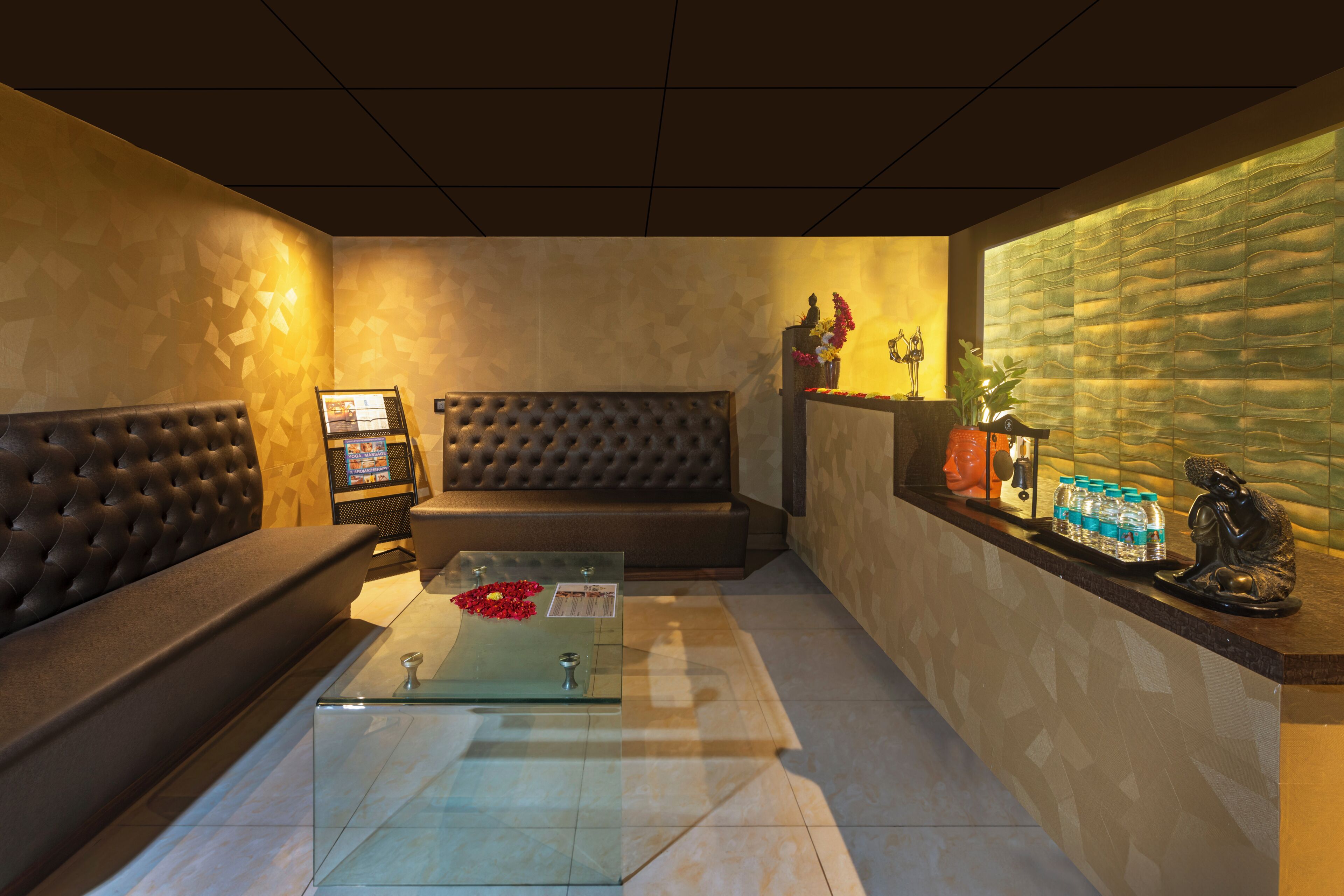 Eine moderne Lobby mit einer Couch, einem Glastisch, einem Empfangstresen und einer Wandverkleidung.