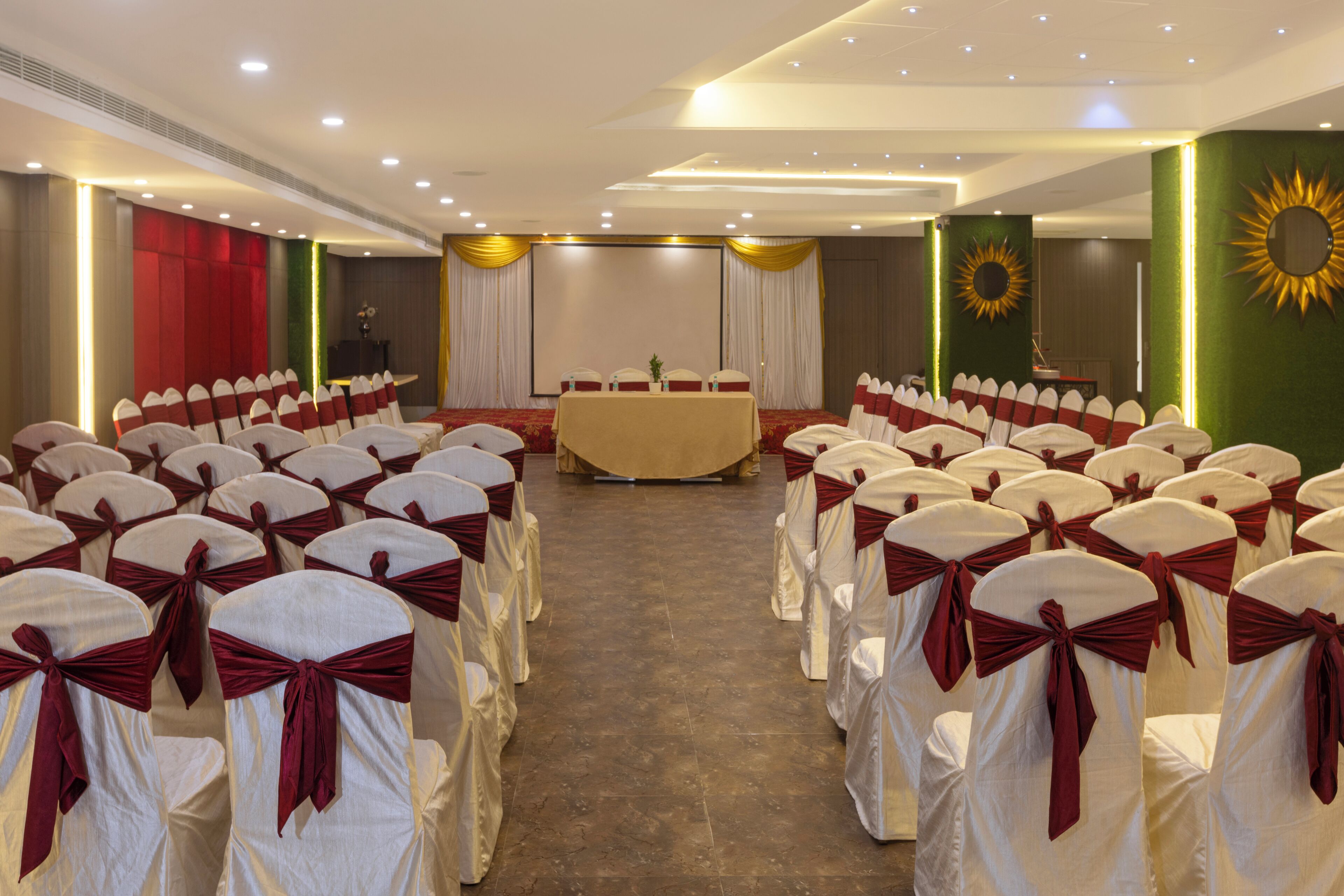 A conference room with rows of chairs, a table, and a stage.