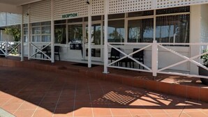A reception area with a tiled floor, white railings, and a sign that reads "RECEPTION". - Dawson Motel (Lismore)