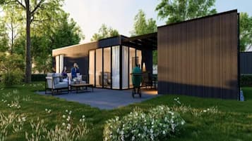 Een modern terras buiten met een zithoek, een barbecue en een houten constructie.