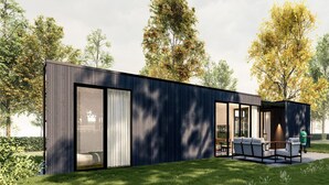 Een modern gebouw met grote schuifdeuren, een terras met buitenmeubels en een verzorgd gazon.