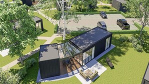 A modern house with a large glass facade, a patio with outdoor furniture, and a well-maintained lawn. - Palette Resort De-steppe Family Stay (Ulicoten)