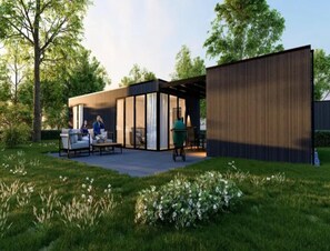 A modern outdoor patio with a seating area, a grill, and a wooden structure. - Family Retreat by Palette Resort De-steppe (Ulicoten)