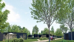 A modern outdoor area with a paved walkway, a car, and several buildings with dark exteriors. - Family Retreat by Palette Resort De-steppe (Ulicoten)