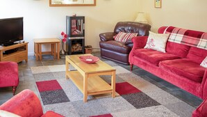 A living room with a television, a fireplace, a sofa, and a coffee table. - Little Content Farm Cottage (Gunwalloe, near Helston)