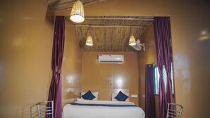 A single bed with a headboard, two bedside tables, and a window with curtains. - Pushkar Desert View (Pushkar)