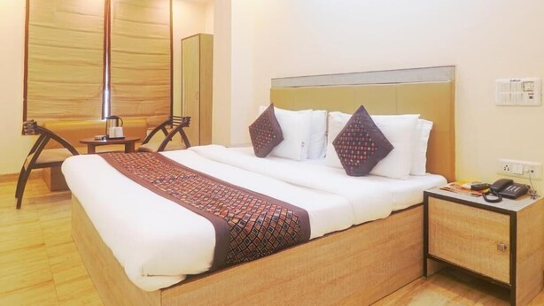 Una habitación de hotel con una cama grande, una mesita de noche y un escritorio con una silla.