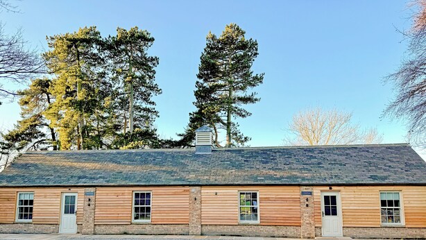 A wooden building with a gravel driveway, labeled 'THISTLE,' and large windows. - Fern Tree Cottage - UK50962 (Kirklington near, Bedale)
