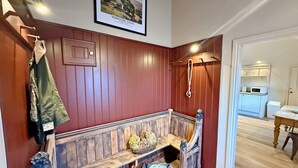 A wooden bench with a basket and a pet bed, a coat rack, and a framed picture on the wall. - Fern Tree Cottage - UK50962 (Kirklington near, Bedale)