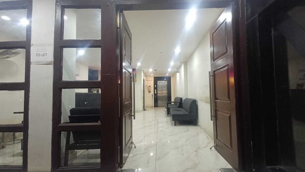 A hotel lobby with a marble floor, a reception desk, and a waiting area with chairs. - Motel Rajadani Residency (Hyderabad)
