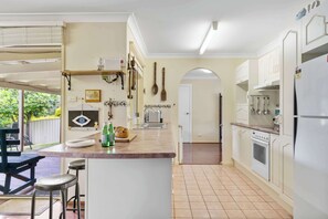 Eine Küche mit Kochinsel, weißen Schränken und einem Essbereich mit Tisch und Stühlen.