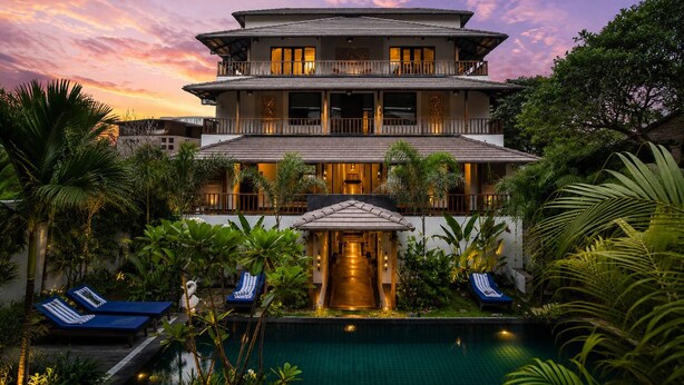 A multi-story hotel with a swimming pool, outdoor seating, and lush greenery. - ANANTYA AT ANAMIVA (Anjuna)